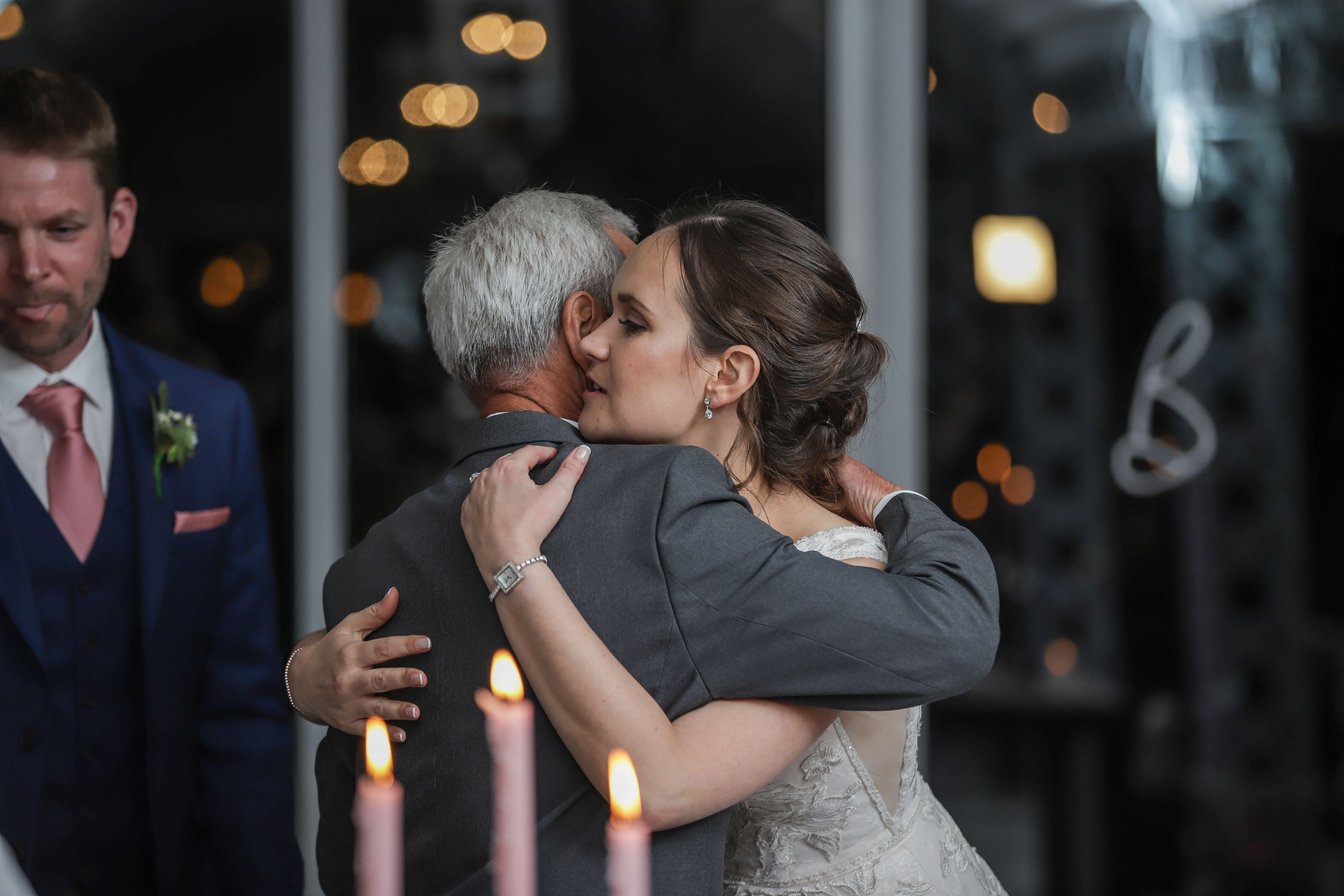 A bride hugging her father after his wedding speech.