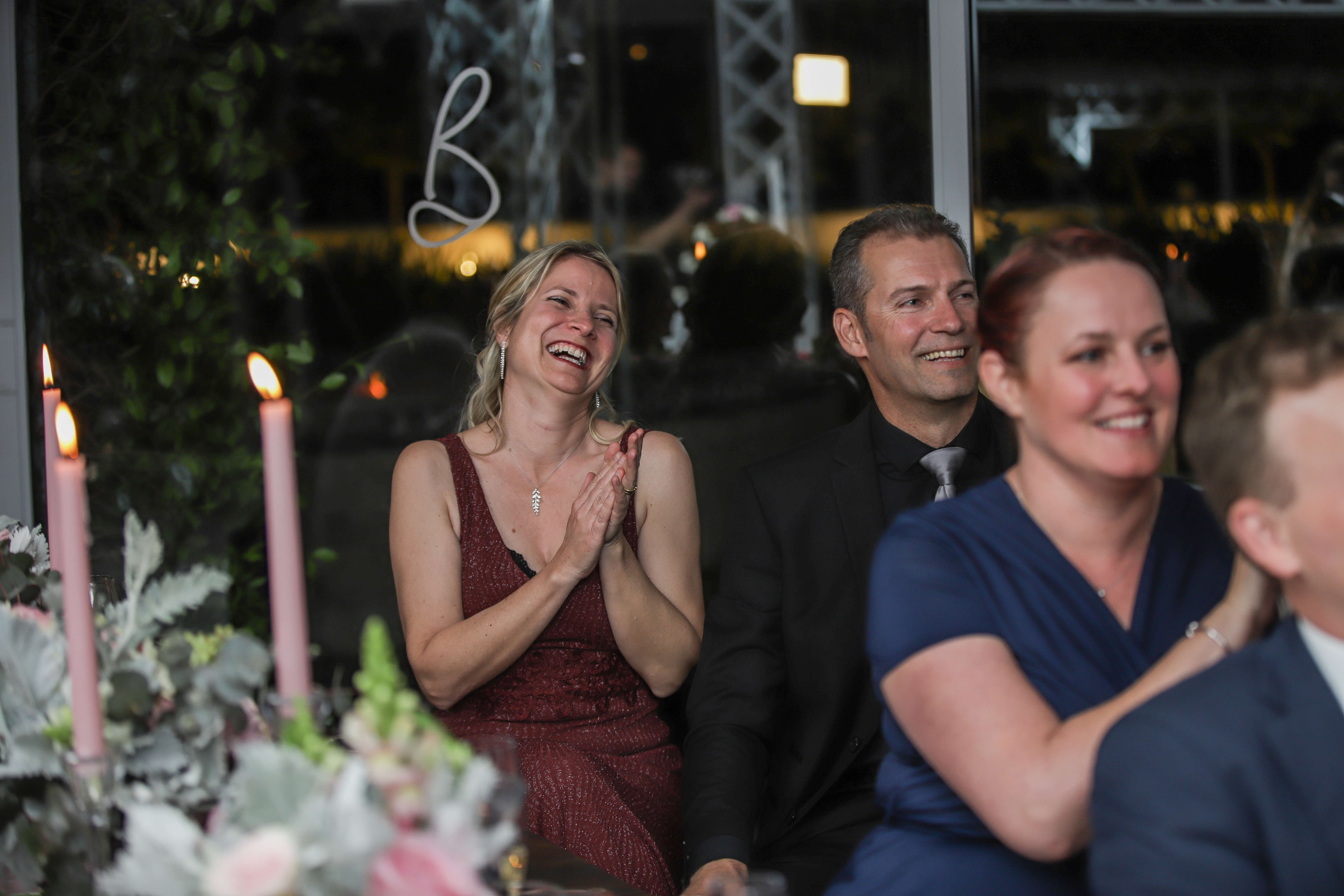 Guests clapping, smiling and laughing to a wedding speech in Stellenbosch.