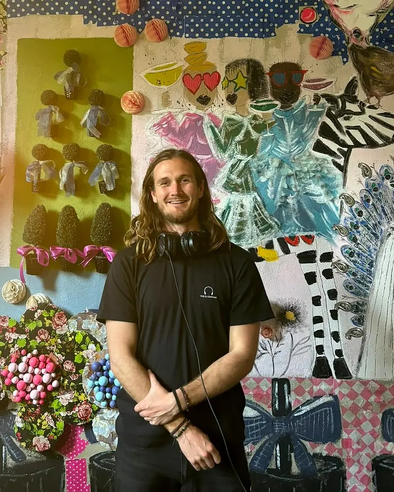 Adrian with his headphones on in front of a painted mural