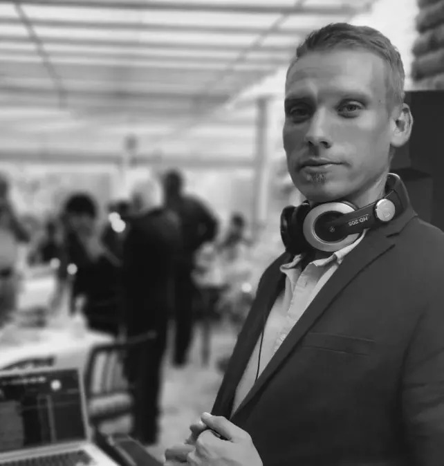 Marc at an event with his headphones round his neck