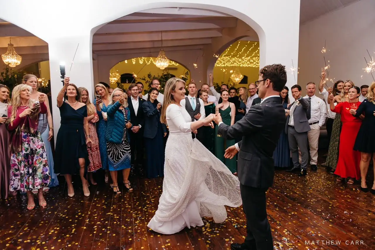 Camilla twirling her sequinned gown as she holds Nick's hand for the first dance, guests raising sparklers all around