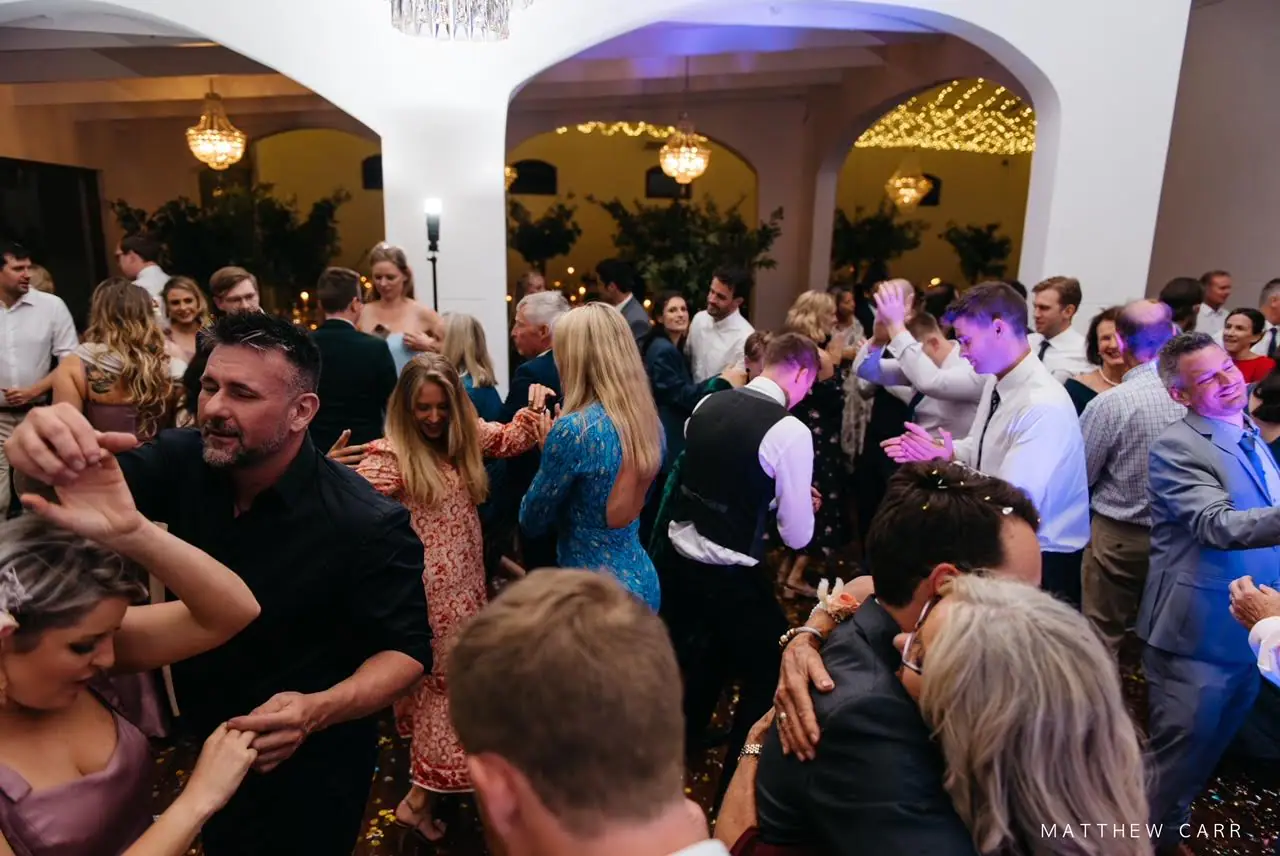 Packed wedding dance floor under crystal chandeliers and fairy-lit arches at Zorgvliet Wines in Stellenbosch