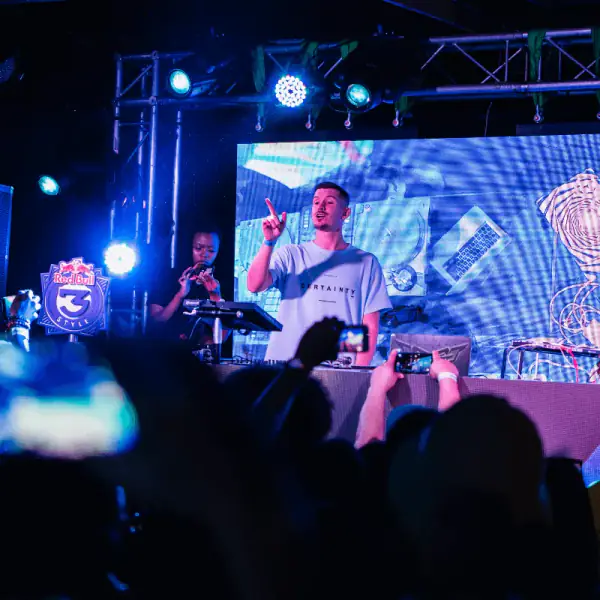 DJ performing on a truss stage in front of an LED screen at a Red Bull South Africa event