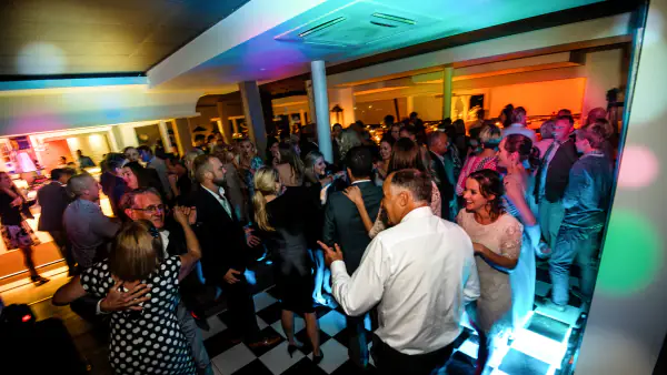 Packed dance floor under colourful party lighting at a Plettenberg Bay wedding