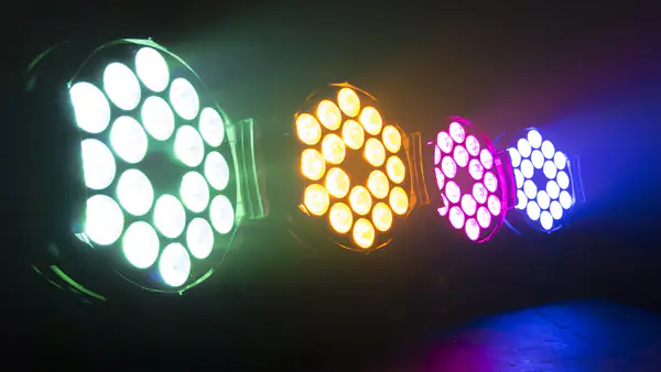 Four LED uplighters glowing white, amber, magenta and blue