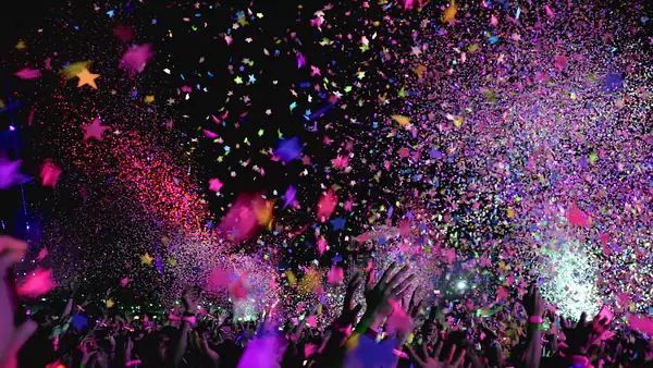 Confetti cannon showering colourful confetti over a cheering crowd