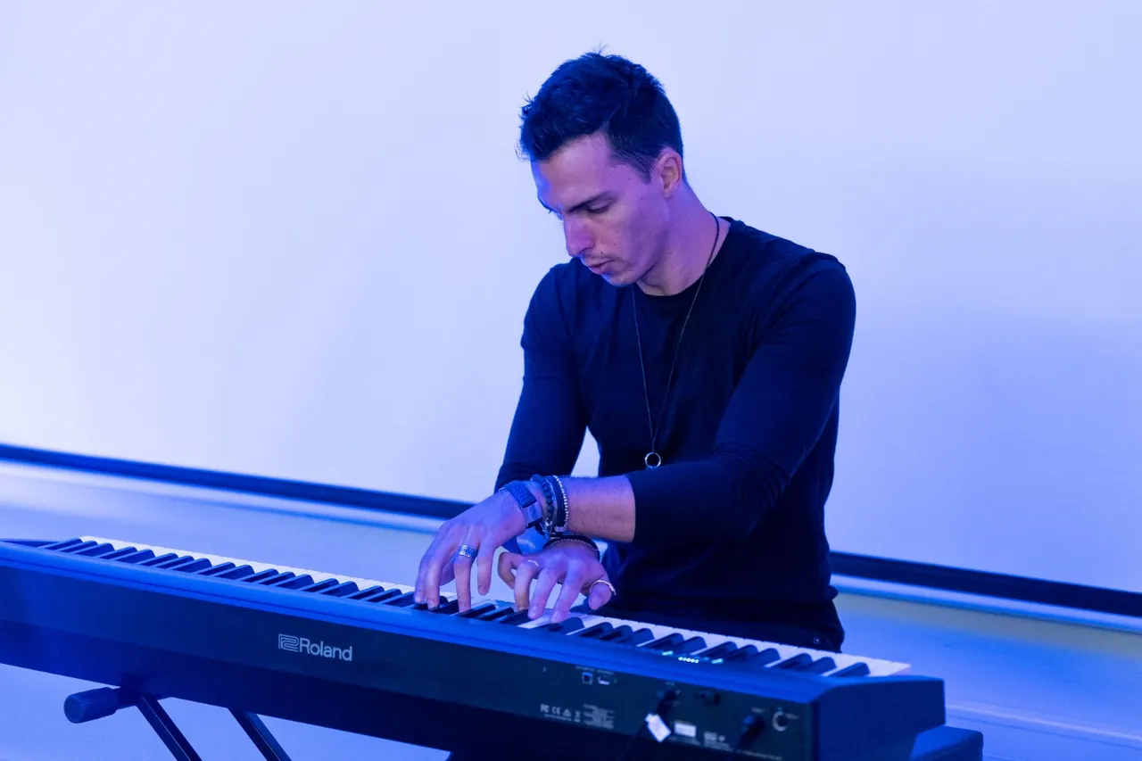 Liam playing a keyboard under blue light