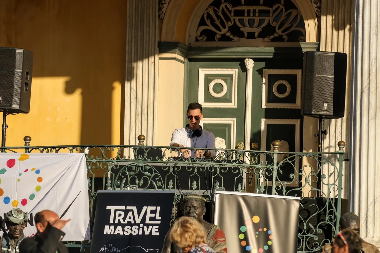 Liam DJing on a balcony above the courtyard at the Castle, speakers either side