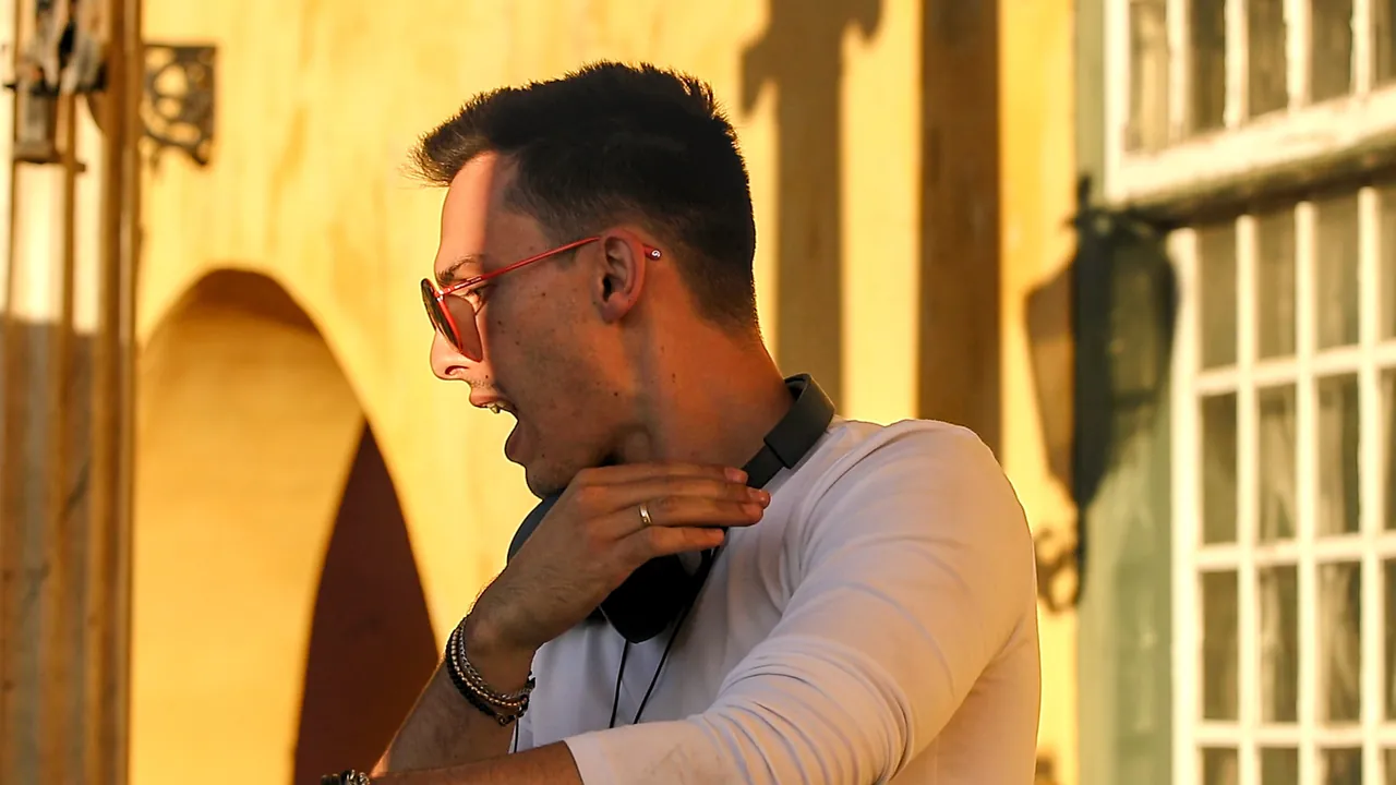 Liam at the decks in the afternoon sun, headphones round his neck